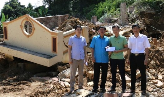 Đồng chí Nguyễn Văn Chung, Tỉnh ủy viên, Chủ tịch Liên đoàn Lao động tỉnh Hà Giang (thứ 2 từ trái qua) trao hỗ trợ tới gia đình anh Huấn ngay tại nơi ngôi nhà bị sập. Ảnh: Trí Hiếu.