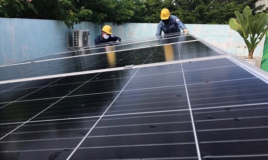 Thanh niên công nhân EVNHCMC lắp đặt hệ thống điện mặt trời mái nhà tặng Nhà thiếu nhi Quận 4. Ảnh Đức Long