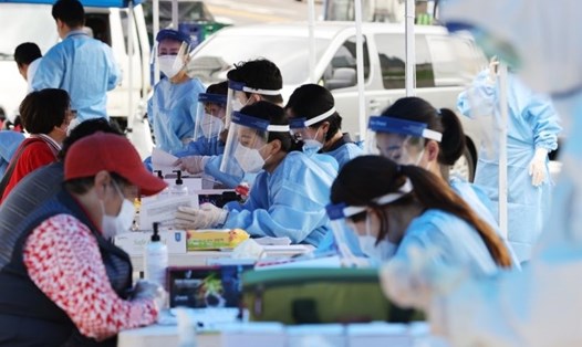 Nhân viên y tế tiến hành xét nghiệm COVID-19 cho người dân tại 1 cơ sở được dựng tạm thời ở chợ Namdaemun, Seoul, Hàn Quốc hôm 10.8. Ảnh: Yonhap