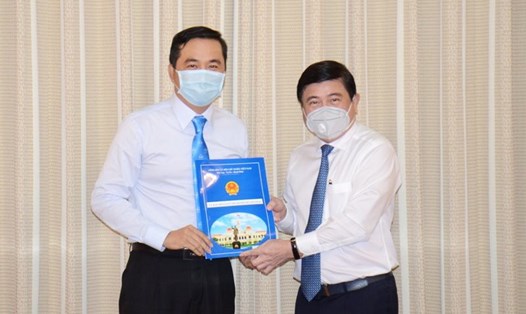 Chủ tịch UBND TPHCM Nguyễn Thành Phong (bìa phải) trao quyết định cho ông Bùi Tá Hoàng Vũ. Ảnh: PHƯƠNG THÙY