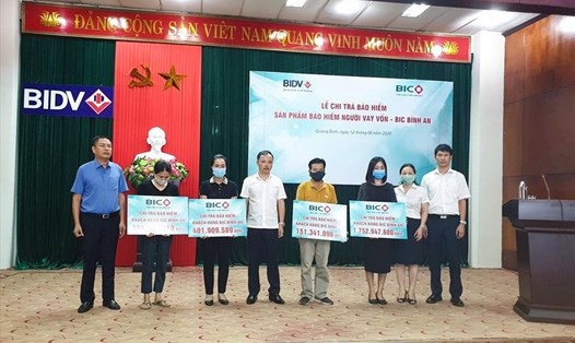 Đại diện BIC va BIDV Quảng Bình trao tiền bảo hiểm cho gia đình các khách hàng. Ảnh: BIC