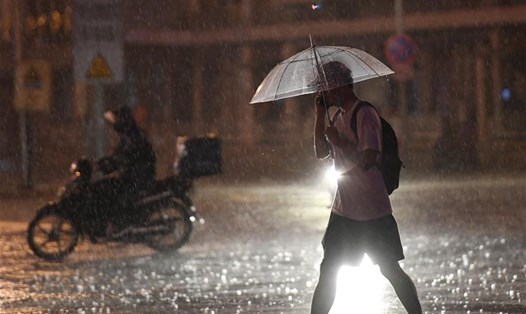 Một người đi trong mưa ở quận Triều Dương, Bắc Kinh hôm 12.8. Ảnh: Tân Hoa Xã.