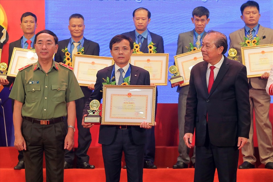Phó Thủ tướng Thường trực Trương Hòa Bình và Thứ trưởng Bộ Công Anh Trần Quốc Tỏ trao Bằng khen cho đồng chí Vũ Khánh Vinh. Ảnh: CĐ DKVN