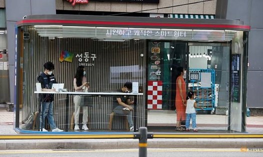 Người dân tại một nhà chờ xe buýt ở Seoul, Hàn Quốc, với camera ảnh nhiệt, khử trùng bằng tia cực tím, điều hòa không khí, camera giám sát và biển chỉ dẫn kĩ thuật số được lắp đặt nhằm ngăn ngừa lây lan COVID-19. Ảnh: Reuters