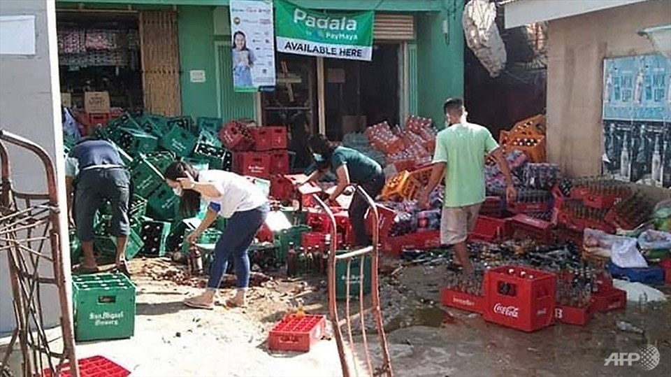 Các công nhân dọn dẹp đống chai lọ đổ vỡ sau trận động đất mạnh 6,7 độ richter gần thị trấn Cataingan ở tỉnh Masbate, miền Trung Philippines ngày 18.8. Ảnh: AFP