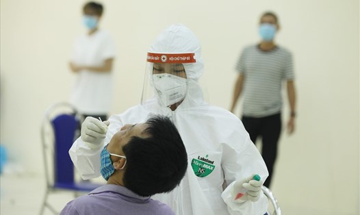 Cán bộ y tế lấy mẫu xét nghiệm PCR cho người dân tại quận Cầu Giấy- Hà Nội. Ảnh: Hải Nguyễn
