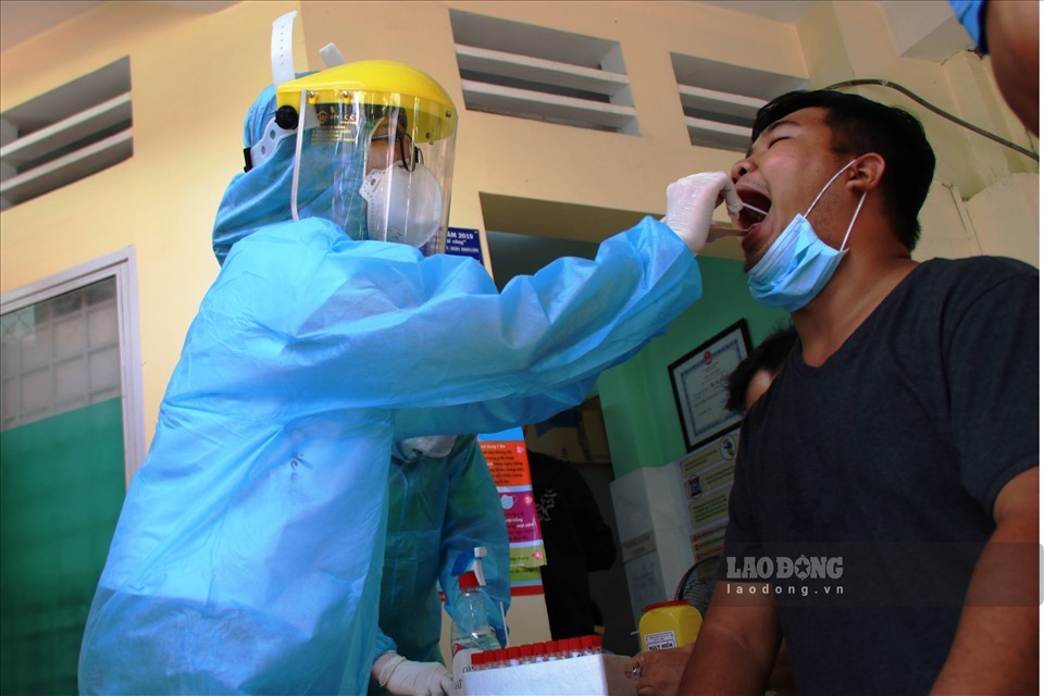 Lấy mẫu xét nghiệm sàng lọc người về từ Đà Nẵng. Ảnh: ANH NHÀN