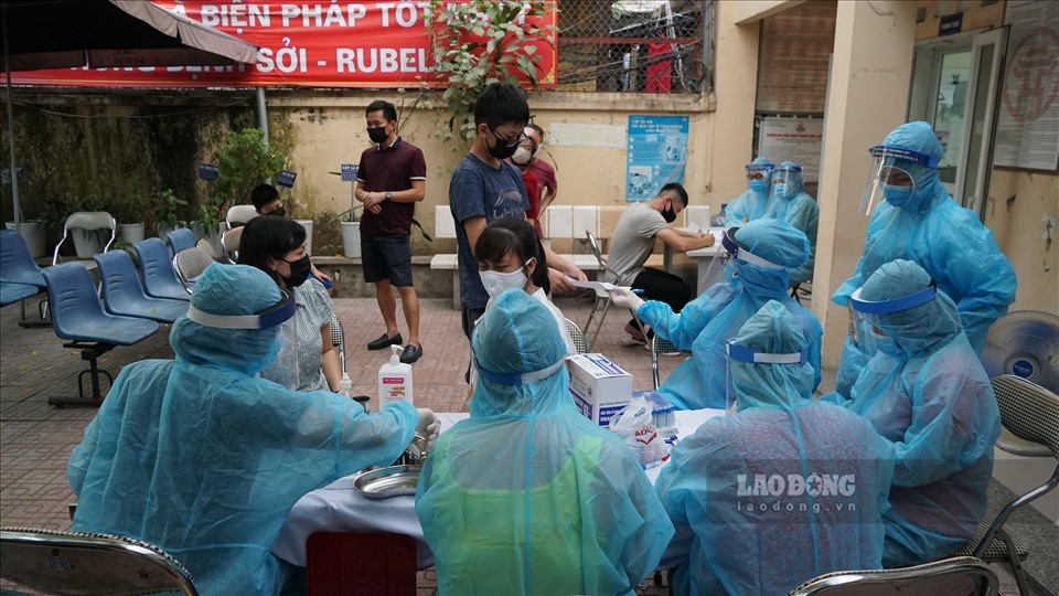 Lấy mẫu xét nghiệm test nhanh COVID-19 cho người dân. Ảnh: Lao Động