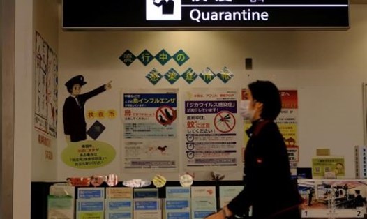 Nhân viên hàng không đeo khẩu trang đi qua quầy kiểm dịch tại sân bay Narita ở Tokyo, Nhật Bản. Ảnh: Reuters