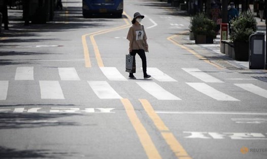 Một phụ nữ đeo khẩu trang đi dạo gần trung tâm mua sắm ở thủ đô Seoul, Hàn Quốc hôm 20.8. Ảnh: Reuters