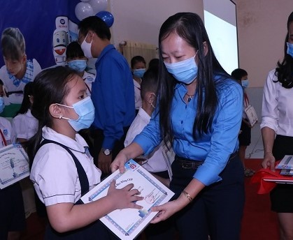 Bà Ong Thụy Hoàng Mai, Phó Chủ tịch LĐLĐ tỉnh Bình Dương trao học bổng CEP cho các em học sinh. Ảnh: Khánh Phong