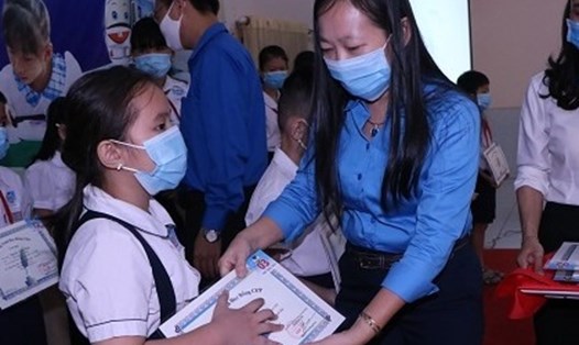 Bà Ong Thụy Hoàng Mai, Phó Chủ tịch LĐLĐ tỉnh Bình Dương trao học bổng CEP cho các em học sinh. Ảnh: Khánh Phong