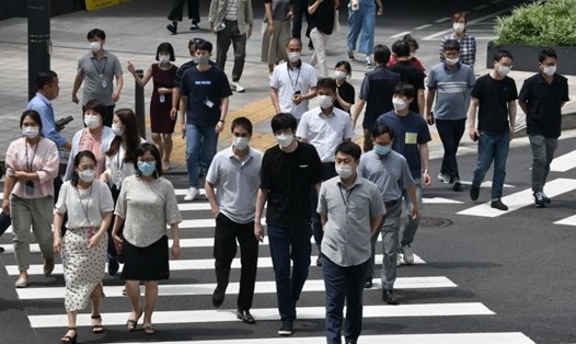 Người dân Hàn Quốc đeo khẩu trang khi ở ngoài đường trong bối cảnh dịch COVID-19 quay trở lại "mạnh mẽ". Ảnh: AFP