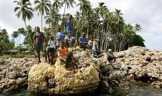 Cư dân đảo ngồi trên một rặng san hô ở đảo Ranongga của Solomon. Ảnh: AFP