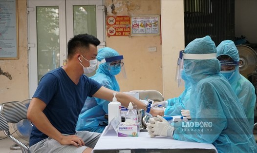 Lấy mẫu xét nghiệm COVID-19 cho người dân ở Hà Nội. Ảnh: Lao Động