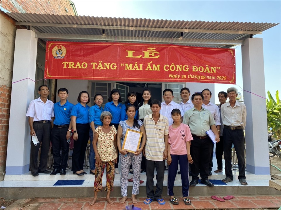 Các đại biểu chụp ảnh lưu niệm với gia đình đoàn viên được trao tặng nhà. Ảnh LĐLĐ Tây Ninh