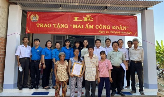 Các đại biểu chụp ảnh lưu niệm với gia đình đoàn viên được trao tặng nhà. Ảnh LĐLĐ Tây Ninh