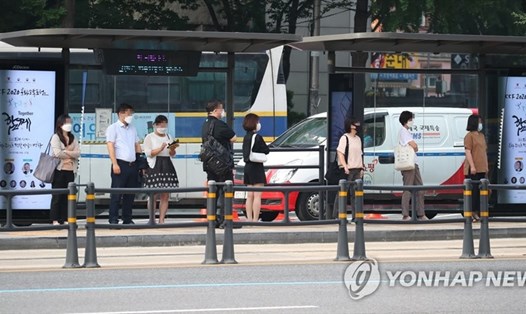 Người dân chờ xe bus trong khi giữ khoảng cách chống dịch COVID-19 tại 1 bến xe ở Seoul, Hàn Quốc hôm 25.8. Ảnh: Yonhap