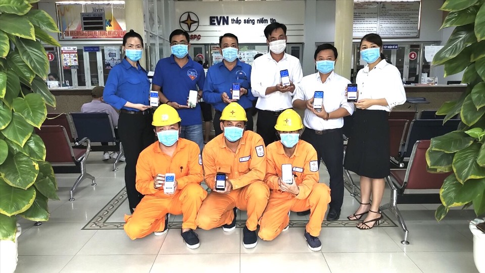Đoàn viên công đoàn Công ty điện lực Bình Dương hưởng ứng cài đặt ứng dụng Bluezone. Ảnh: Quang Vinh