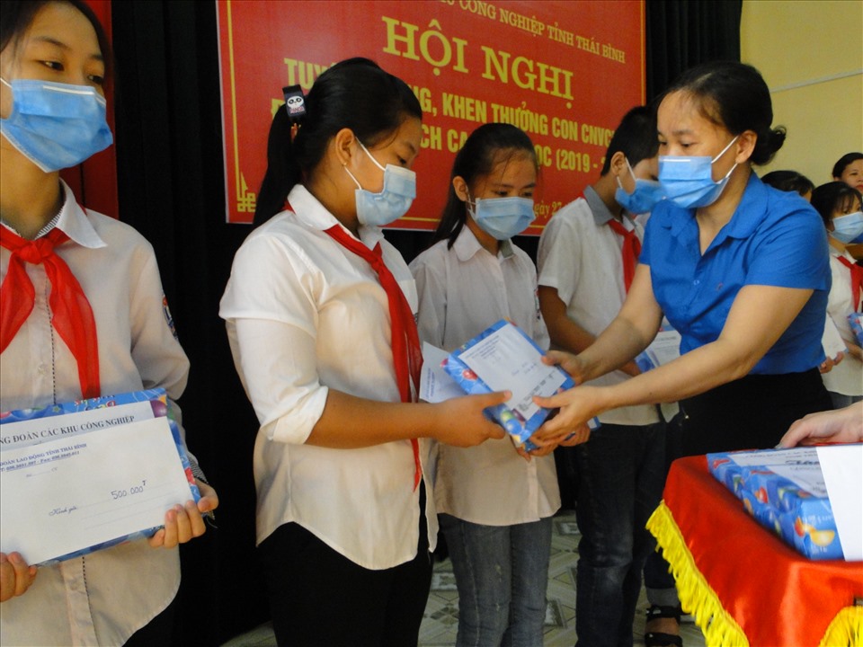 Con của công nhân lao động vượt khó học giỏi được bà Phạm Thị Thắng - Chủ tịch Công đoàn các khu công nghiệp Thái Bình trao quà và tuyên dương tại hội nghị. Ảnh: Bá Mạnh