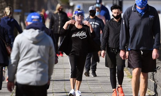 Một số người cao tuổi đeo khẩu trang, khiên chắn tập thể dục dọc theo bãi biển Port Melbourne, Melbourne, Australia hôm 10.8. AFP.