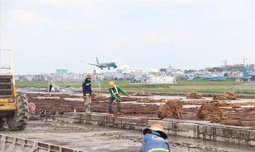 Công nhân thi công nâng cấp đường băng cất hạ cánh 25R/07L sân bay Tân Sơn Nhất.  Ảnh: Minh Quân