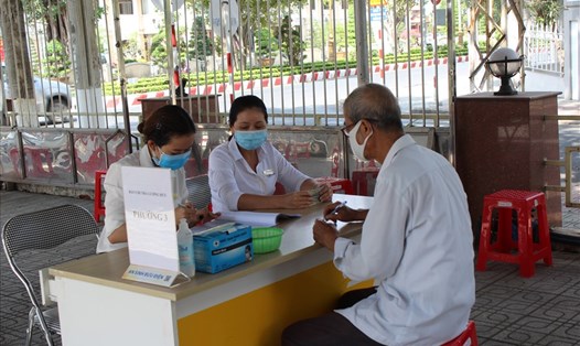 Nhân viên Bưu điện tỉnh Tiền Giang chi trả lương hưu, trợ cấp BHXH tại điểm chi trả. Ảnh BHXH cung cấp.