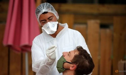 Nhân viên y tế lấy mẫu xét nghiệm COVID-19 trên bệnh nhân ở Bassin de la Villette, Paris, Pháp ngày 25.8. Ảnh: Reuters
