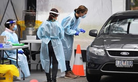 Nhân viên tại một trạm xét nghiệm COVID-19 ở Melbourne, bang Victoria, Australia, tiến hành kiểm dịch. Ảnh: AFP.