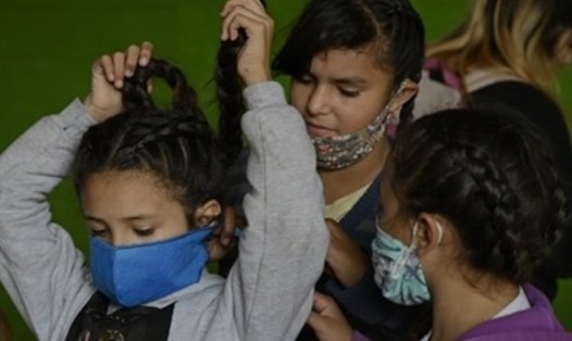 Trẻ em đeo khẩu trang để ngăn ngừa sự lây lan của COVID-19. Ảnh: AFP