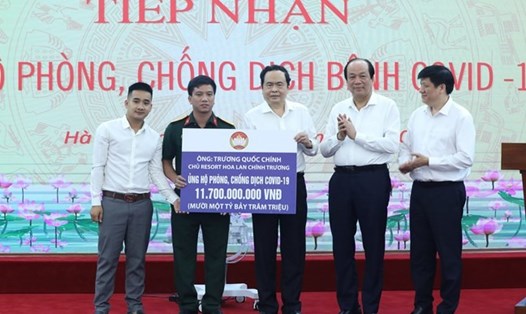 Chủ tịch Uỷ ban Trung ương MTTQ Việt Nam Trần Thanh Mẫn cùng các đại biểu tiếp nhận số tiền 11,7 tỉ đồng từ cuộc đấu giá hoa lan. Ảnh: Kỳ Anh