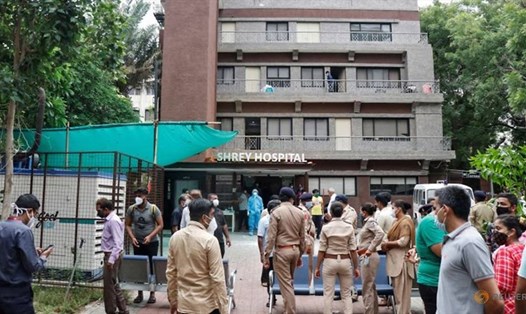 Nhân viên cảnh sát và thân nhân người bệnh bên ngoài bệnh viện nơi xảy ra hỏa hoạn  khiến 8 bệnh nhân COVID-19 thiệt mạng, ở Ahmedabad, Ấn Độ, ngày 6.8. Ảnh: Reuters