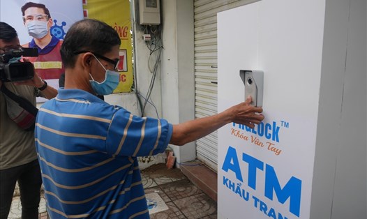 Người dân nhận khẩu trang miễn phí tại điểm "ATM phát khẩu trang". Ảnh: Anh Tú