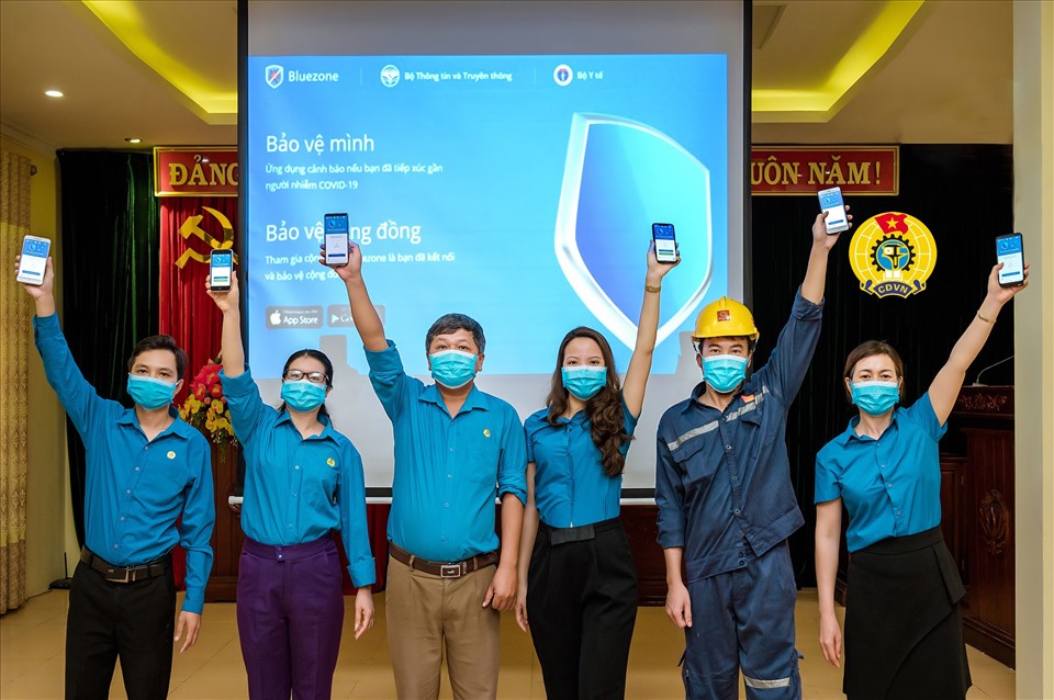 Cán bộ công đoàn và đoàn viên huỵện Thanh Liêm cài đặt ứng dụng Bluezone. Ảnh: Hoàng Hải.