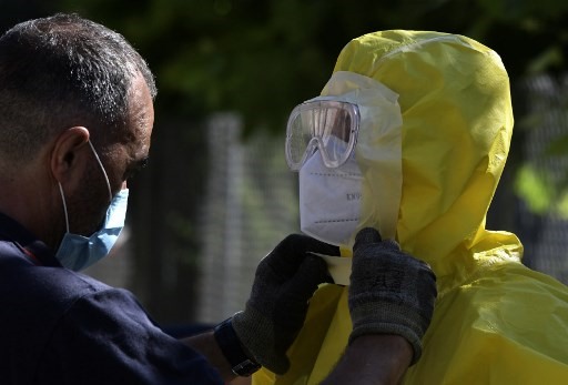 Nhân viên y tế chỉnh lại trang phục bảo hộ trước khi xét nghiệm COVID-19 tại một viện dưỡng lão ở Tây Ban Nha. Ảnh: AFP