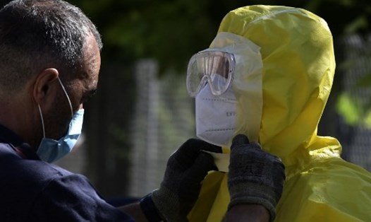 Nhân viên y tế chỉnh lại trang phục bảo hộ trước khi xét nghiệm COVID-19 tại một viện dưỡng lão ở Tây Ban Nha. Ảnh: AFP