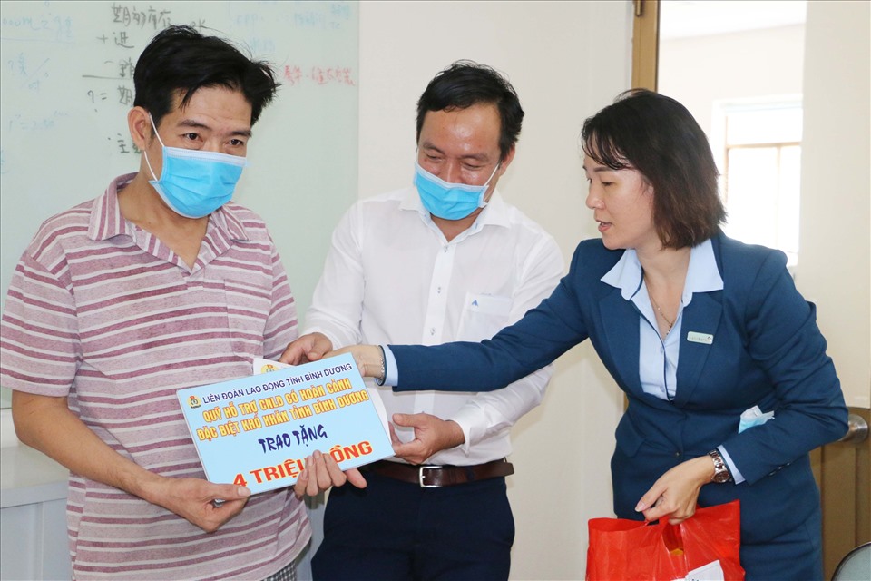 Đại diện Vietinbank Bình Dương (bìa phải) và ông Nguyễn Đình Khánh-Phó Chủ tịch Thường trực LĐLĐ tỉnh Bình Dương trao hỗ trợ cho công nhân Nguyễn Tuấn Kiệt. Ảnh: Hoàng Trung