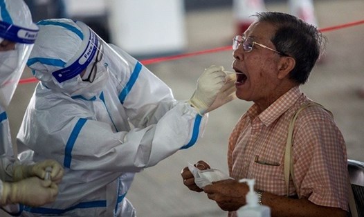 Nhân viên y tế lấy mẫu xét nghiệm COVID-19 cho 1 tài xế ở Hồng Kông hôm 19.7. Ảnh: AFP.