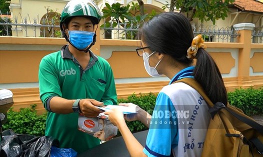 Anh Trần Văn Quý (33 tuổi, ngụ quận 8, TPHCM) phát khẩu trang cho sĩ tử trước các điểm thi. Ảnh: Ngọc Lê