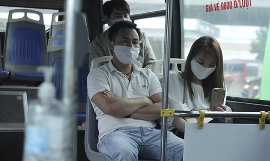 Hành khách lên xe buýt được yêu cầu đeo khẩu trang, rửa tay sát khẩu phòng dịch COVID-19. Ảnh T.Vương