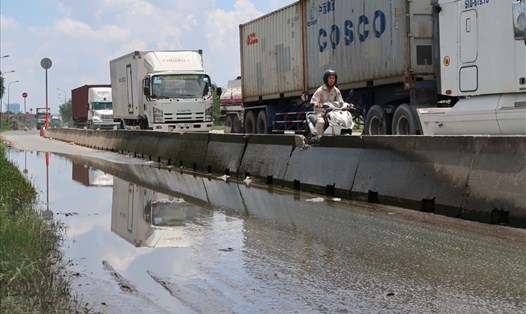Xe máy đi vào làn ô tô, xe tải, xe container để tránh vũng nước đọng trên đường Võ Chí Công (quận 2, TPHCM). Ảnh: Hữu Huy
