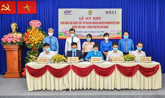 Bà Thái Thị Lan Chi (giữa), Chủ tịch LĐLĐ Quận Tân Bình đại diện ký thỏa ước lao động tập thể với 4 doanh nghiệp ngành dệt may trên địa bàn quận. Ảnh Đức Long