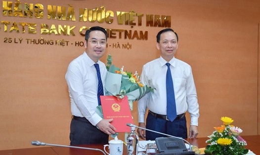 Phó Thống đốc Thường trực Ngân hàng Nhà nước Việt Nam Đào Minh Tú trao quyết định cho tân Vụ trưởng Vụ Tín dụng các ngành kinh tế Nguyễn Tuấn Anh (trái).