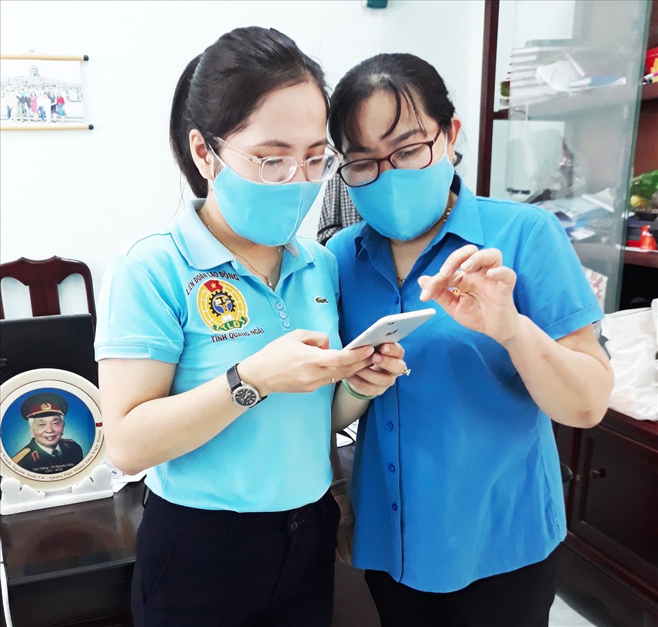 Cán bộ LĐLĐ tỉnh Quảng Ngãi hướng dẫn đoàn viên cài đặt ứng dụng Bluezone. Ảnh: Thanh Thuỷ