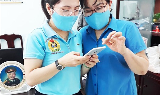 Cán bộ LĐLĐ tỉnh Quảng Ngãi hướng dẫn đoàn viên cài đặt ứng dụng Bluezone. Ảnh: Thanh Thuỷ