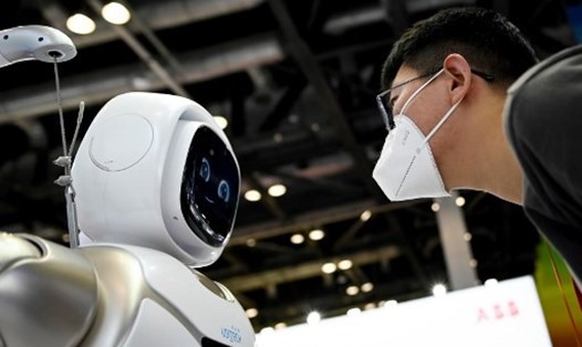 Người đàn ông đeo khẩu trang đang nhìn robot tại buổi Hội chợ Thương mại Dịch vụ Quốc tế Trung Quốc. Ảnh: AFP
