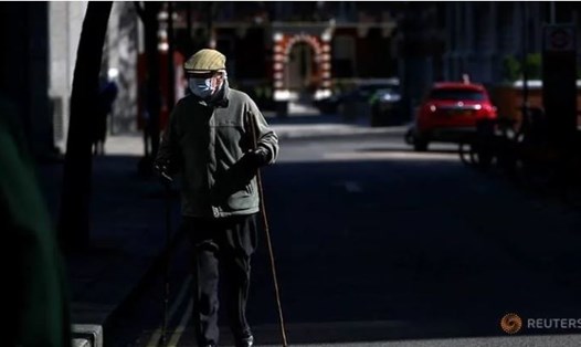 Một người cao tuổi đeo khẩu trang và găng tay tại Luân Đôn, Anh trong bối cảnh đại dịch COVID-19 đang lây lan nhanh chóng ở nước này hồi cuối tháng 3. Ảnh: Reuters