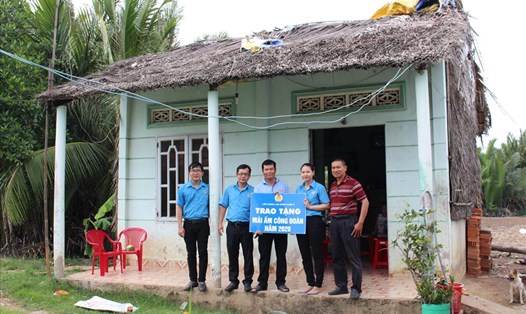Đại diện LĐLĐ Quận 8 trao bảng tượng trưng kinh phí để xây, sửa nhà "Mái ấm Công đoàn" cho đoàn viên Phạm Minh Hùng. Ảnh Đức Long