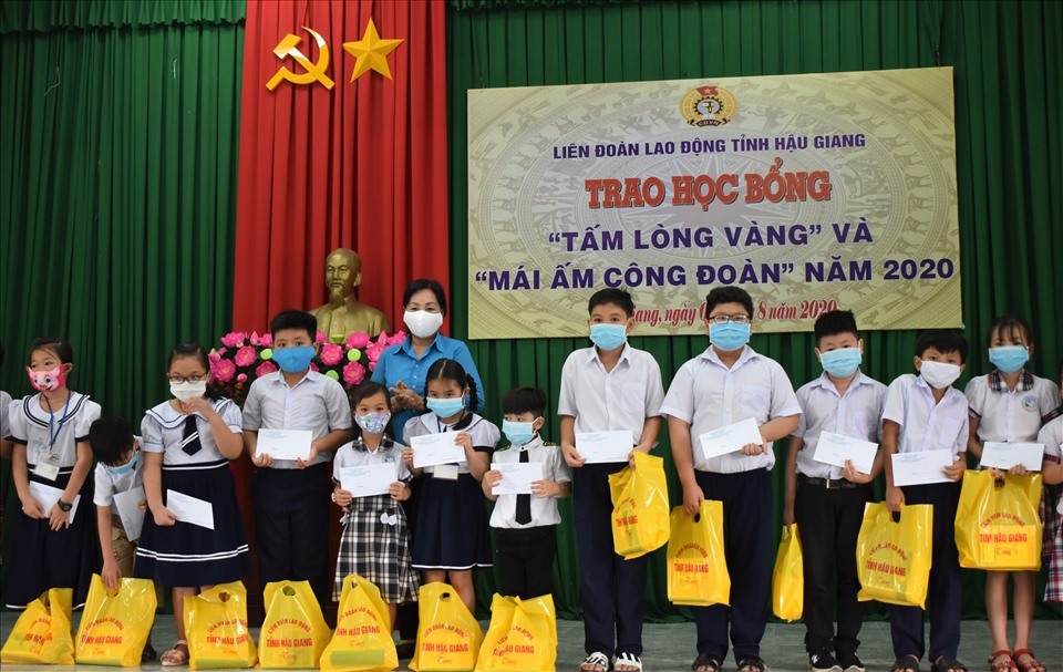 Phó Chủ tịch LĐLĐ tỉnh Hậu Giang Trương Thị Ánh Nguyệt trao học bổng các em học sinh, sinh viên vượt khó học giỏi. Ảnh: Thành Nhân