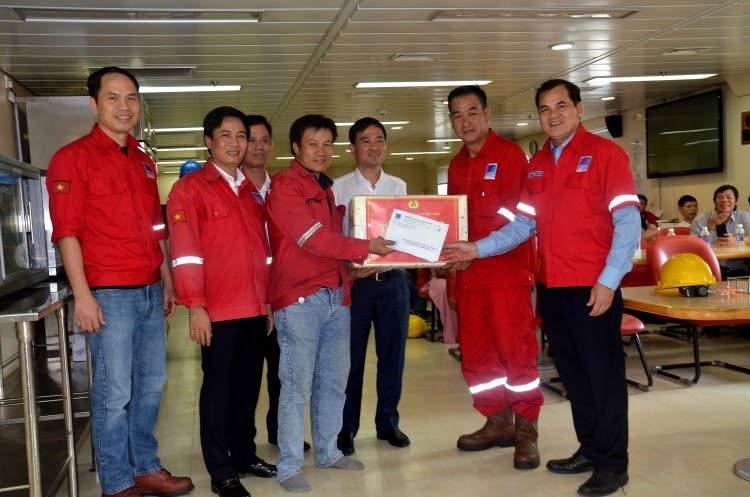 Đồng chí Vũ Anh Tuấn và đồng chí Hồ Trọng Thoán tặng quà cho người lao động trên giàn PV Drilling V. Ảnh: Hồng Thắm